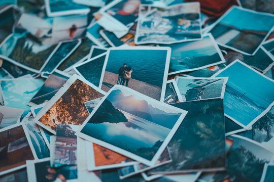 A heap of printed travel photographs strewn on the ground, echoing memories and the wanderlust spirit. Lost or forgotten memories concept