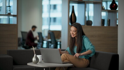 Fototapeta premium Positive director using laptop in lounge zone closeup. Satisfied person at sofa