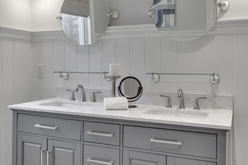 Minimal Luxury Grey and White Bathroom Interior with Double Vanity, Decorative Mirrors, Towel Racks, and Wainscoted Walls