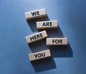 Help symbol. Wooden blocks with words We are here for you. Beautiful grey background. Business and We are here for you concept. Copy space.