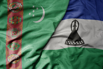 big waving national colorful flag of lesotho and national flag of turkmenistan.