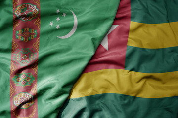 big waving national colorful flag of togo and national flag of turkmenistan.