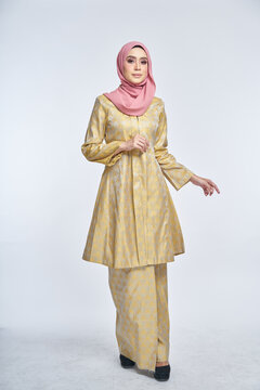 Beautiful female model wearing kebaya made from songket with hijab, an Asian traditional dress for Muslim woman isolated over white background. Eidul fitri fashion and beauty. 