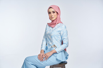 Beautiful female model wearing blue peplum dress with hijab, a modern lifestyle outfit for Muslim...