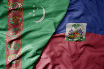 big waving national colorful flag of haiti and national flag of turkmenistan.