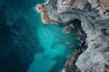 An overhead perspective capturing a large expanse of water and its surrounding landscape, A cinematic shot from above of a turquoise sea and weathered cliffs, AI Generated - obrazy, fototapety, plakaty