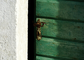 Old wooden half-open door with a rusty vintage doorknob
