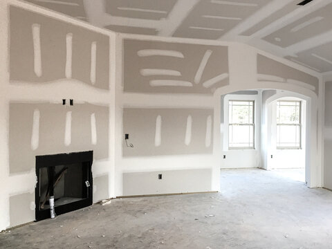 Drywall and taping interior of house construction