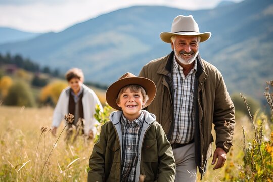 Grandfather and grandson walk in the mountains amid tall grass