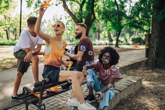 An interracial group of friends having fun in a city park.