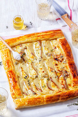 Puff pastry pie with cheese, pears, nuts and honey, served with champagne. - 764294541