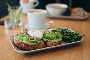 Bread Toast and Poached Egg with Green Salad and Avocado. Breakfast concept. Morning time. Avocado egg sandwich with whole grain bread