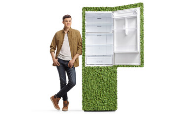 Young man in checkered shirt and jeans leaning on a sustainable fridge