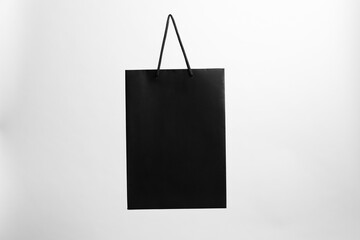 One black paper shopping bag on grey background