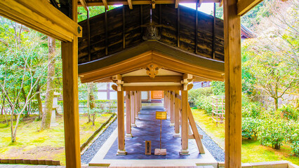 Fototapeta na wymiar Kyoto, Japan - March 25 2016: The entrance of a temple building with a sakura tree