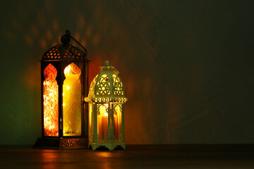 Decorative Arabic lanterns on table against dark background. Space for text