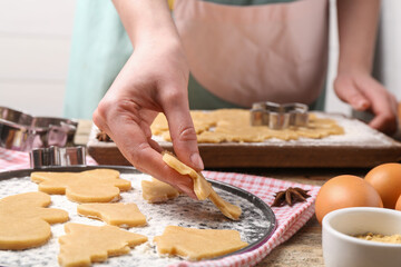 Woman making Christmas cookies at wooden table, closeup