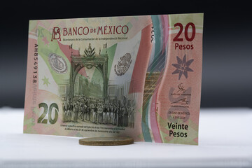 Billete de 20 pesos y moneda de 10 mexicanos.