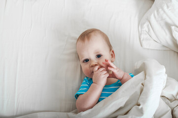 Baby 11 months old on the bed getting ready to sleep.