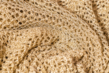 Closeup of wrinkled mesh fabric with golden thread