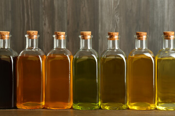 Vegetable fats. Different oils in glass bottles on wooden table