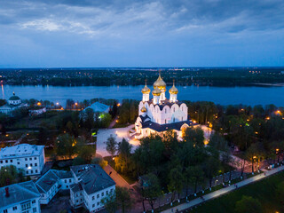 Scenic view from drone of medieval Yaroslavl Orthodox Assumption cathedral on background with Volga River and cityscape at night, Russia..