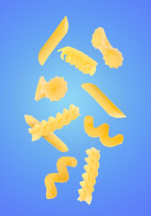 Different types of pasta flying on blue background