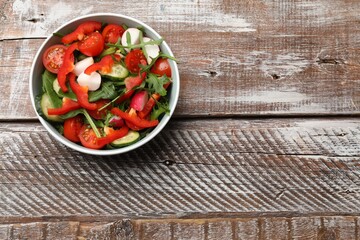 Tasty fresh vegetarian salad on wooden table, top view. Space for text