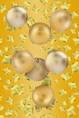 Golden Christmas balls and confetti falling on goldenrod background