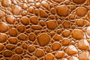 Brown imitation crocodile skin texture. Fake leather for the background
