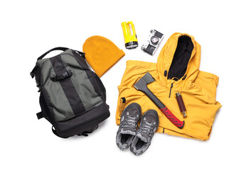 Set of hiking essentials with backpack, raincoat and outdoor gear on white background