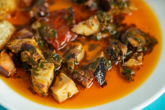 A plate of food with a red sauce and a green garnish