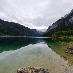 The water in the lake is like a mirror reflecting the mountains and sky. Gosaus, Austria 2022