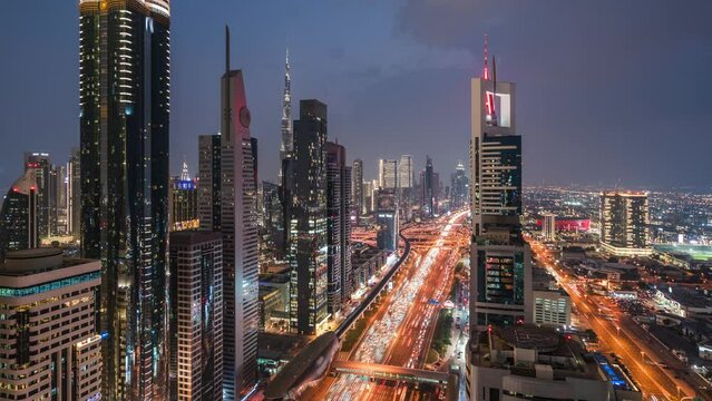 Dusk to night timelapse view of traffic and skyscrapers along Sheikh Zayed Road in Dubai, United Arab Emirates (UAE), zoom out.