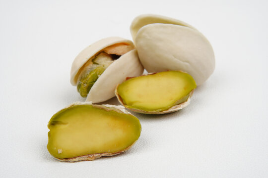 Peeled and unpeeled pistachio nuts isolated on white background