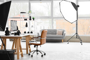 Interior of modern studio with photographer's workplace and professional equipment