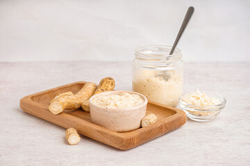 Horseradish sauce in bowls and jar with ground horseradish on white background