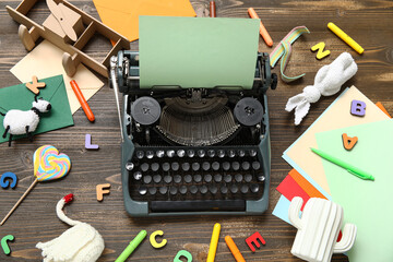 Composition with vintage typewriter, knitted toys and green paper on dark wooden background