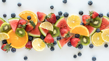 A top down view of a narrow line of various pieces of fruit.
