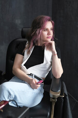 Fototapeta premium Portrait of a female hairdresser with professional scissors and pink comb in barber shop