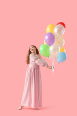 Young woman with balloons on pink background