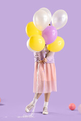 Fototapeta na wymiar Young woman with balloons on lilac background