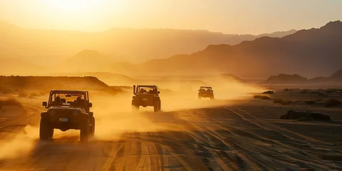 Poster A convoy of off-road vehicles raises clouds of dust while driving through a desert landscape during a picturesque sunset. © RicardoLuiz