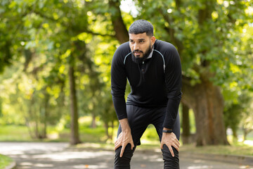 Exhausted runner taking a break in the park