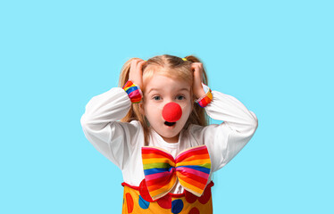 Surprised girl in clown costume on blue background