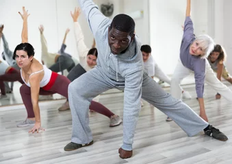 Photo sur Plexiglas Anti-reflet École de danse African-american guy practising dance moves with other people in dance studio