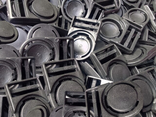 pile of black plastic hook buttons. a set of black identification card hooks or buttons. industrial...