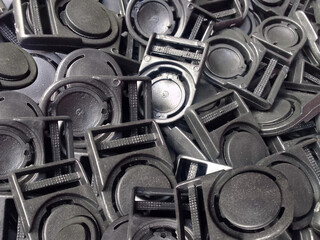 pile of black plastic hook buttons. a set of black identification card hooks or buttons. industrial plastic stopper