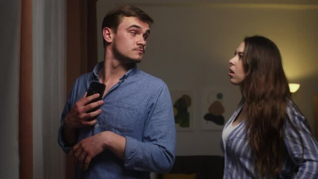 Couple's Tense Moment: Woman Confronting Man Over Secretive Phone Use