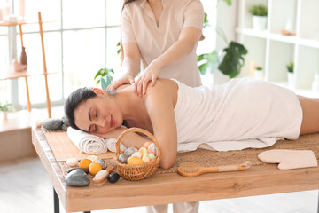 Young woman getting massage in spa salon on Easter Day